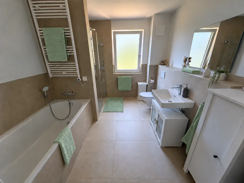 Tageslichtbad mit Badewanne, separater Dusche und Waschplatz
