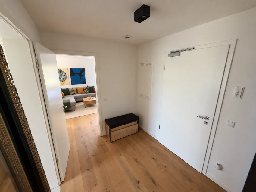Eingangsbereich mit Sitzbank, Wohnungstür und Blick ins Wohnzimmer
