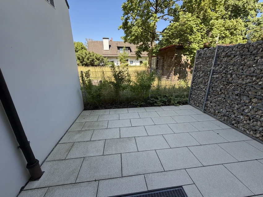 Große Terrasse ohne Möblierung mit Blick in den Garten