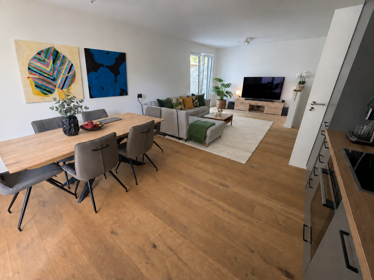 Offener Wohn- und Essbereich mit Parkett, Holzesstisch und großzügigem Sofa